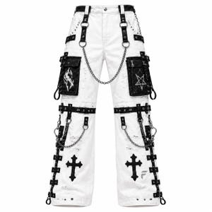 Puede incluir: Pantalones cargo blancos con correas negras, anillas de metal y cadenas plateadas. Los pantalones incluyen bolsillos cargo negros con estampados gráficos blancos de un lobo y un pentagrama, además de aplicaciones de cruces negras y detalles desgastados.