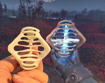 Op de afbeelding: Een 3D-geprint model van een wit, geometrisch, kooi-achtig object. Het object wordt in de hand van een persoon gehouden. Op de achtergrond is een vergelijkbaar object te zien in een videogame.