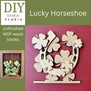 May include: An unfinished MDF wood blank in the shape of a horseshoe decorated with multiple four-leaf clover cutouts. The item features a flat base for standing and is presented alongside a smaller inset image showing a finished version.