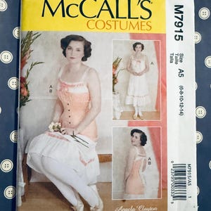 May include: McCall's Costumes sewing pattern M7915. The pattern features a woman in a peach-colored corset and white skirt. The pattern includes multiple views and sizes A5 (6-8-10-12-14). The designer is Angela Clayton.