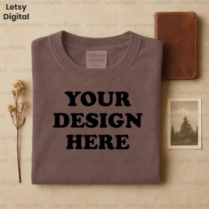 Vintage Braun T-Shirt Mockup | Gefaltet Hemd im Rustikalen Flatlay | Leder Geldbörse & Natur Print Tee Mockup