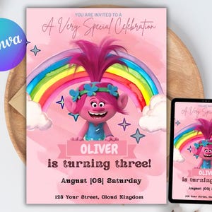 以下が含まれることがあります： ピンク色の誕生日招待状。漫画のキャラクター、虹、そして「OLIVERは3歳になります！」というテキストが特徴です。招待状には日付と住所が含まれています。デジタルタブレットには同じデザインが表示されます。