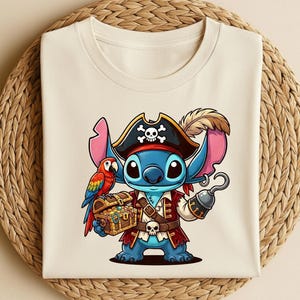 K&ouml;nnte beinhalten: Cremefarbenes T-Shirt mit einer Cartoon-Piratenfigur mit blauer Haut, die einen Piratenhut mit Totenkopf und gekreuzten Knochen tr&auml;gt. Die Figur h&auml;lt eine Schatzkiste und einen Haken, mit einem Papagei auf ihrer Schulter. Das Design ist detailliert und farbenfroh.
