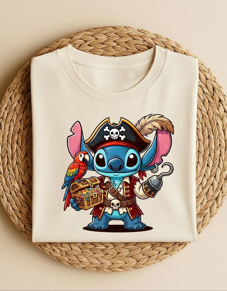 K&ouml;nnte beinhalten: Cremefarbenes T-Shirt mit einer Cartoon-Piratenfigur mit blauer Haut, die einen Piratenhut mit Totenkopf und gekreuzten Knochen tr&auml;gt. Die Figur h&auml;lt eine Schatzkiste und einen Haken, mit einem Papagei auf ihrer Schulter. Das Design ist detailliert und farbenfroh.