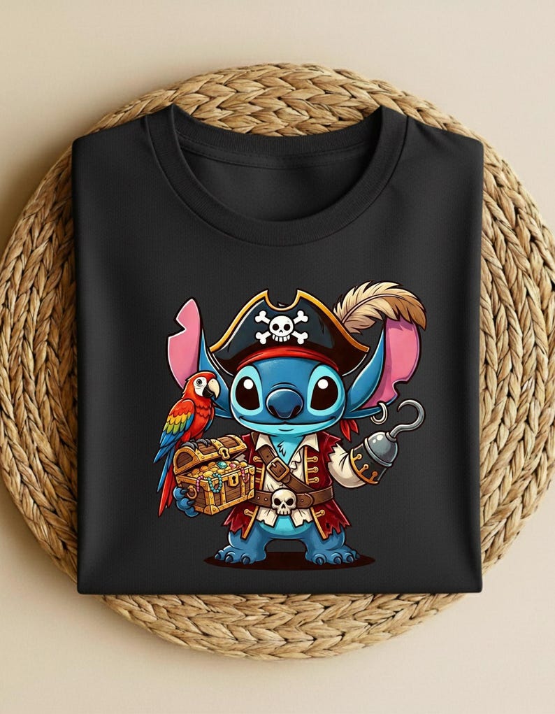 K&ouml;nnte beinhalten: Schwarzes T-Shirt mit einer Cartoon-Figur als Pirat. Die blaue Figur hat gro&szlig;e Ohren und tr&auml;gt einen Piratenhut mit Totenkopf, einen roten Mantel und h&auml;lt einen Haken und eine Schatztruhe. Ein Papagei ist ebenfalls abgebildet.