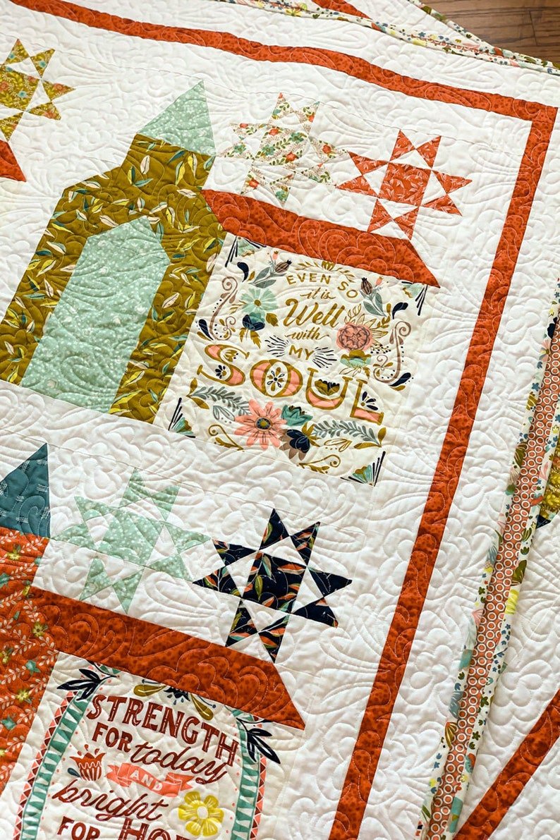 May include: A white quilt with a patchwork design featuring various floral patterns, stars, and text. The text includes "Even so it is well with my soul" and "Strength for today and bright hope for tomorrow".
