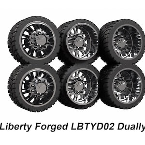May include: Six black and silver Liberty Forged LBYTD02 Dually wheels are stacked in two rows of three. The tires have a thick tread pattern. The wheels have a multi-spoke design with a silver finish.