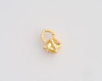 May include: A gold-colored clasp with a bee design. The clasp features a detailed bee charm attached to a rounded loop. The bee has textured wings and body. The clasp is likely for jewelry or accessories.