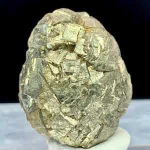 May include: A natural pyrite specimen, also known as fool's gold, with a metallic luster. The mineral has a rough, irregular surface with many small, reflective crystal faces. The pyrite is a golden color and sits on a white base.