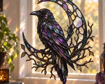 May include: A stained glass suncatcher featuring a black raven perched on a branch within a crescent moon frame. The raven has iridescent purple and blue feathers, while the moon is composed of translucent white, blue, and purple glass segments.