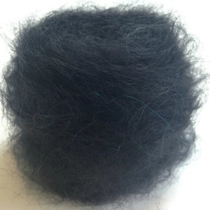 K&ouml;nnte beinhalten: Nahaufnahme einer schwarzen Wollkn&auml;uel. Das Garn ist weich und flauschig und perfekt zum Stricken oder H&auml;keln.