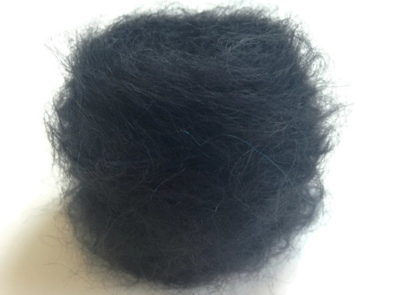 K&ouml;nnte beinhalten: Nahaufnahme einer schwarzen Wollkn&auml;uel. Das Garn ist weich und flauschig und perfekt zum Stricken oder H&auml;keln.