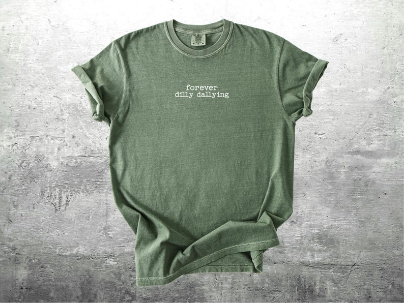 May include: A green t-shirt with the text "forever dilly dallying" printed on the front.