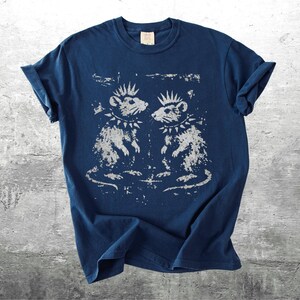 K&ouml;nnte beinhalten: Marineblaues T-Shirt mit einem Used-Look-Motiv von zwei Ratten mit Irokesenschnitt und Nietenhalsb&auml;ndern. Die Ratten blicken sich an. Das T-Shirt hat hochgekrempelte &Auml;rmel und ein Etikett am Ausschnitt.