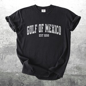 May include: Black t-shirt with white text that reads "GULF OF MEXICO EST 1550".