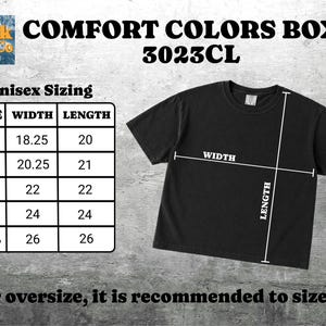 May include: A black short-sleeve t-shirt labeled Comfort Colors Boxy 3023CL. A size chart displays width and length measurements in inches for sizes S through 2XL, with white lines on the shirt indicating where width and length are measured.
