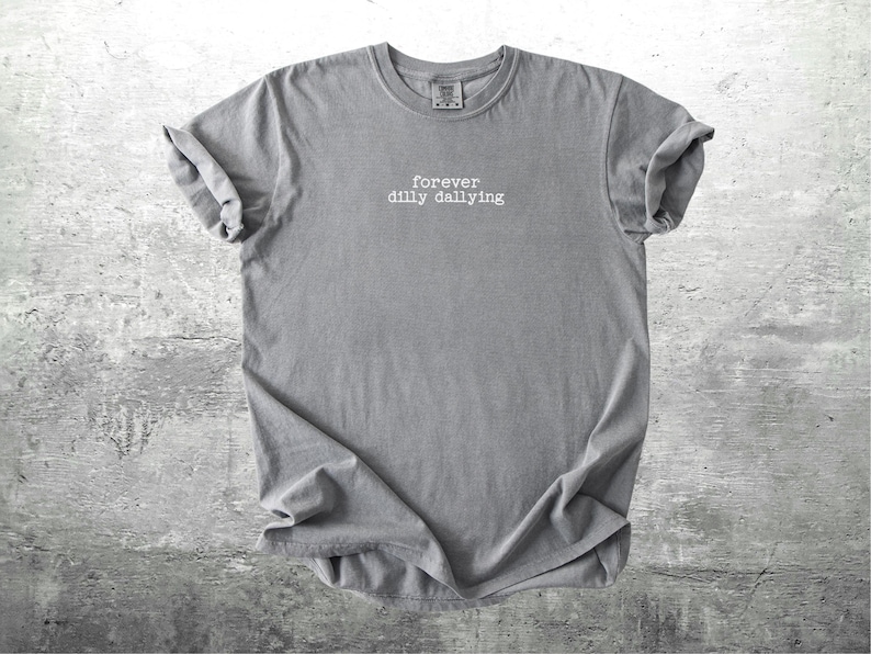 May include: A gray t-shirt with the text "forever dilly dallying" printed in white on the front.