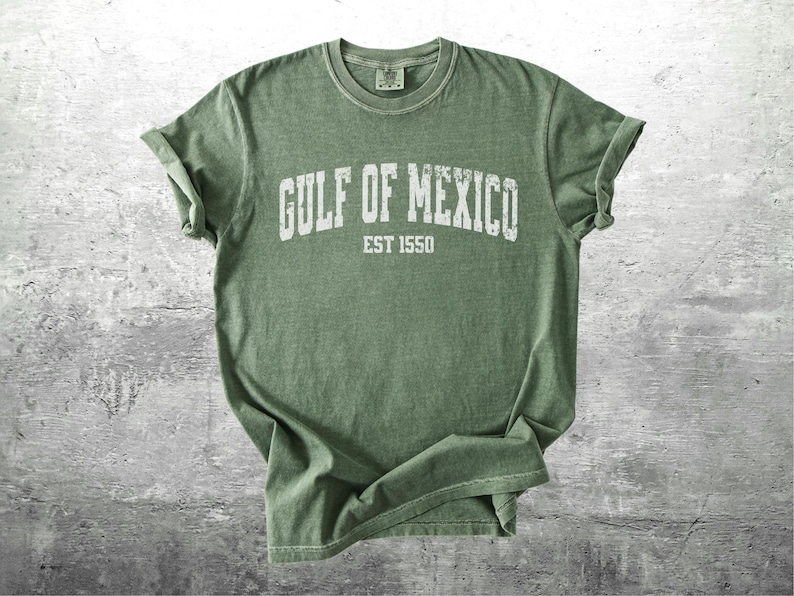 May include: A green t-shirt with the text "GULF OF MEXICO EST 1550" printed in white on the front.