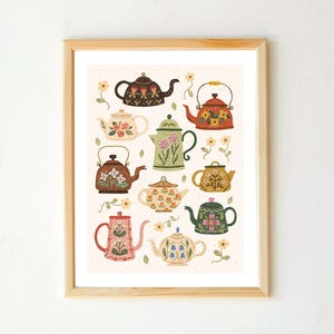 Peut inclure: Une affiche encadrée présentant une collection de théières décoratives aux couleurs et motifs floraux variés. Les théières sont disposées sur un fond beige clair avec de petites illustrations de fleurs. Le cadre en bois ajoute une touche classique à l'œuvre.