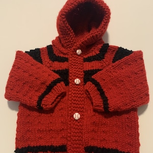 May include: Red knitted hooded cardigan with black stripes and baseball buttons.
