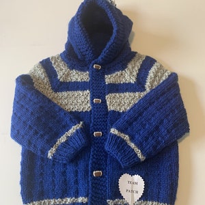 May include: Blue and gray striped knitted baby cardigan with a hood and football-shaped buttons. The cardigan has a white heart-shaped tag that says "Team Patch".