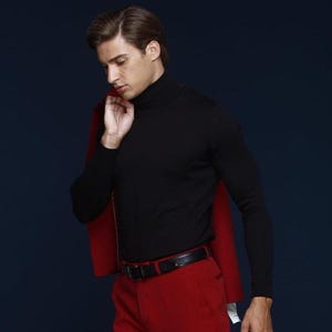 May include: A black turtleneck sweater paired with red pants and a black belt. A red blazer is draped over the shoulder. The outfit is set against a dark blue background.