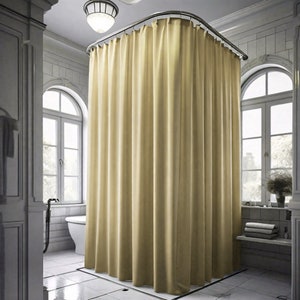 May include: A beige shower curtain hangs from a curved shower rod in a bathroom. The shower curtain is made of a smooth, fabric-like material.