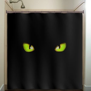 May include: Black shower curtain with two large green eyes printed on it. The eyes are glowing in the dark.