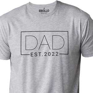 May include: Gray t-shirt with the text "DAD EST. 2022" in a black box.