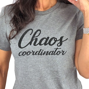 May include: Gray t-shirt with the text "Chaos coordinator" in black cursive lettering.