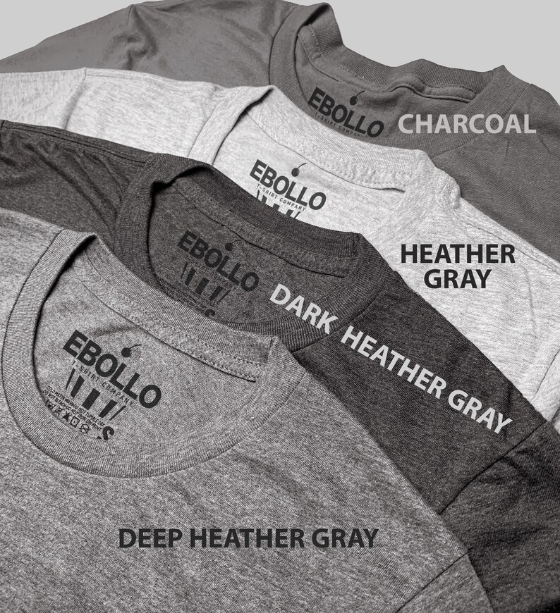 May include: A close-up of several gray t-shirts, each displaying the "EBOLLO T-SHIRT COMPANY" logo. The shirts are in various shades, including charcoal, heather gray, dark heather gray, and deep heather gray. The shirt colors are labeled in white text.