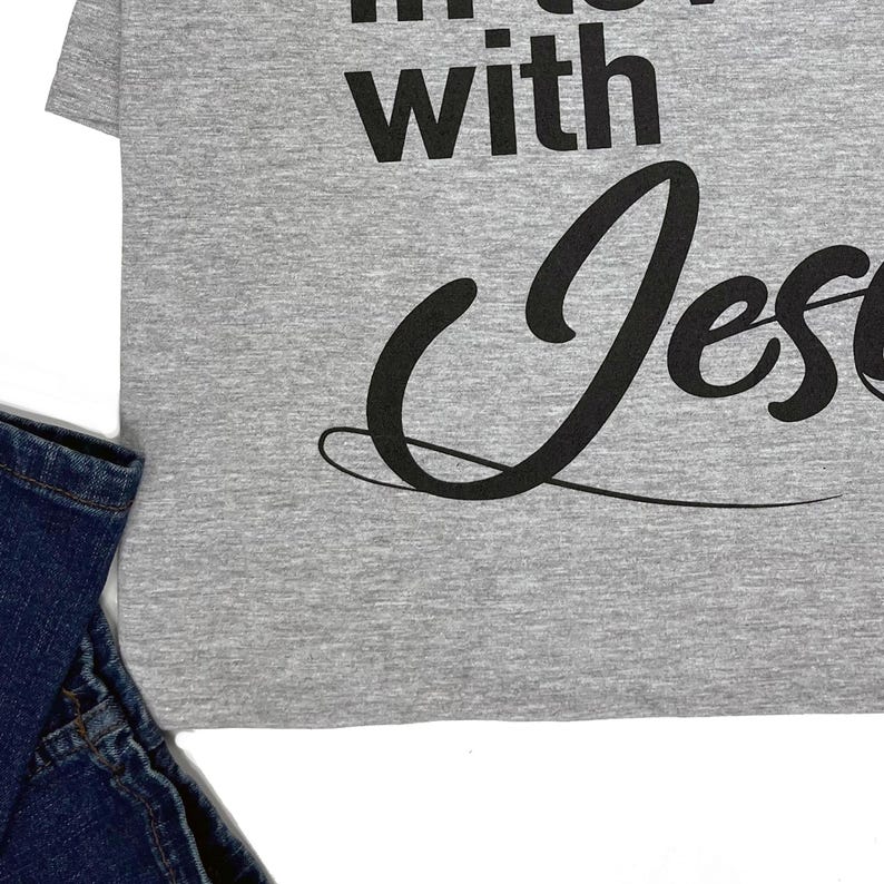 May include: Gray t-shirt with the text "in love with Jesus" printed in black.