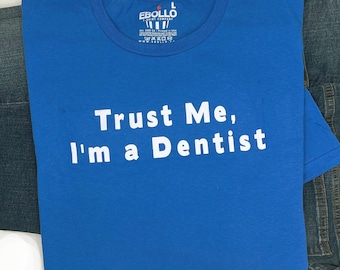 May include: A royal blue t-shirt with white text that reads "Trust Me, I'm a Dentist".