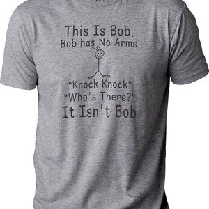 Pu&ograve; includere: T-shirt grigio melange con la scritta "This Is Bob. Bob has No Arms." e un omino stilizzato. Sotto, la battuta "Knock Knock" "Who's There?" "It Isn't Bob."