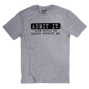 May include: A heather gray t-shirt with the text "ADMIT IT. LIFE WOULD BE BORING WITHOUT ME." in black. The shirt has short sleeves and a crew neck. The brand label is visible at the top.