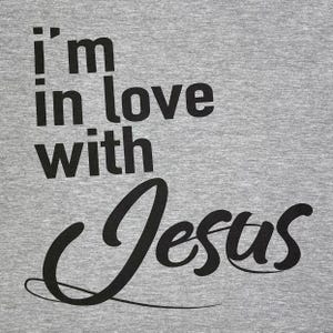 May include: Gray t-shirt with black text that reads "i'm in love with Jesus".