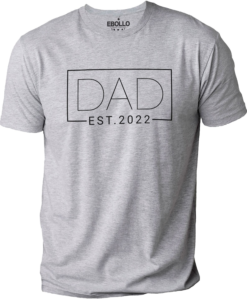 May include: Gray t-shirt with the text "DAD EST. 2022" in a black box.