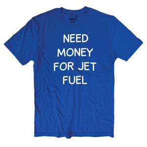 May include: A royal blue t-shirt with the text "NEED MONEY FOR JET FUEL" in white block letters. The shirt is a crew neck style and appears to be made of a soft material. The shirt is a solid color.