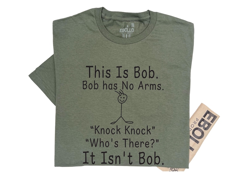 May include: A green t-shirt with the text 'This Is Bob. Bob has No Arms.' and a stick figure drawing of a person with no arms. The text 'Knock Knock' 'Who's There?' 'It Isn't Bob' is also on the shirt.