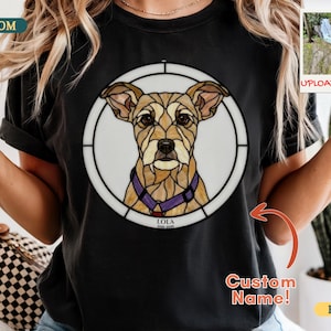Puede incluir: Camiseta negra con un retrato de perro personalizado al estilo vidriera. El diseño presenta un perro marrón claro con un collar morado, dentro de un marco circular blanco. El texto "LOLA" está debajo.