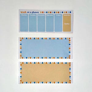 May include: Two blank notepads with blue and orange borders. The top notepad has a weekly planner layout with the days of the week labeled. The bottom notepad is a blank rectangle.