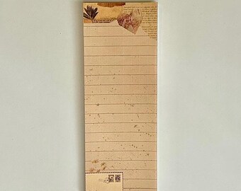 May include: A lined notepad with a vintage aesthetic. The paper is cream colored with brown lines and a subtle speckled pattern. The top of the notepad features a decorative design with a brown leaf and a piece of paper with text.