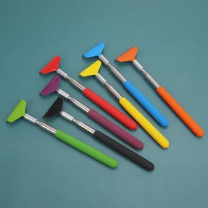 May include: An assortment of colorful, telescoping dusters. Each duster features a vibrant handle and a matching head in shades of green, black, purple, red, yellow, blue, and orange. The extendable metal shafts provide adjustable reach.