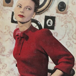 Könnte beinhalten: Eine Frau trägt einen roten Waffelstrickpullover mit einer Schleife am Hals. Der Pullover hat Puffärmel und eine figurbetonte Silhouette.