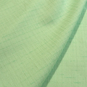 May include: A light mint green fabric with a visible woven texture and a subtle crosshatch pattern. The material is draped to show soft folds and shadows, highlighting the consistent color and the fine, grid-like structure of the textile weave.
