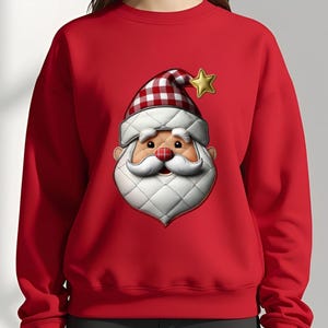 May include: A red sweatshirt featuring a Santa Claus face design. The Santa face has a white quilted beard and hat trim, a red and white checkered hat, and a gold star. The design is centered on the front of the sweatshirt.