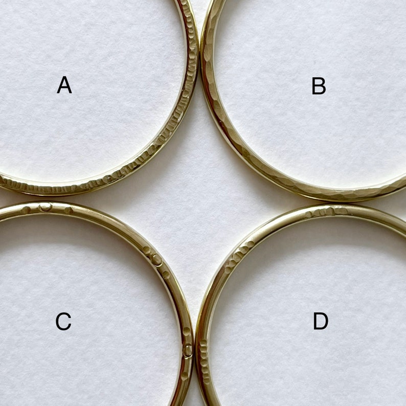 May include: Four gold-coloured metal hoops with a hammered texture. The hoops are labelled A, B, C, and D.