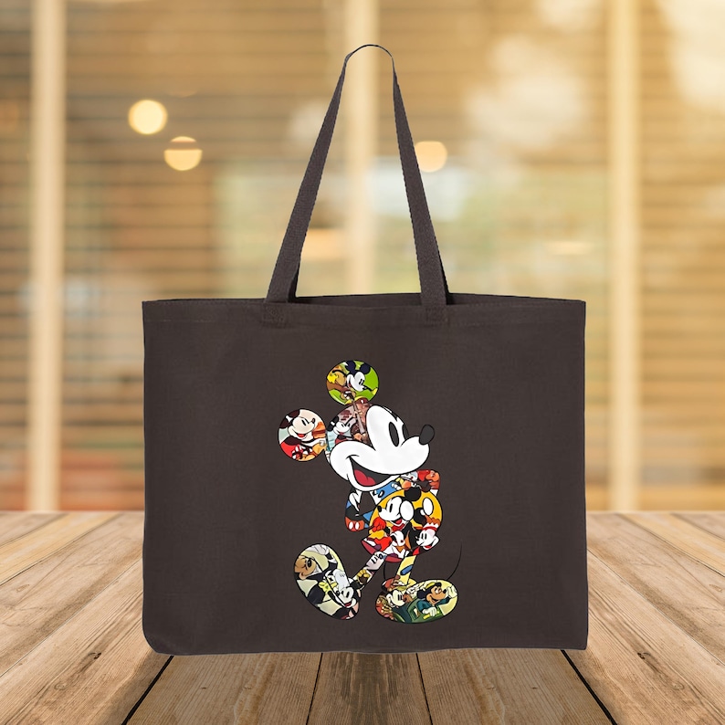 May include: A dark brown tote bag with a colourful Mickey Mouse design. The cartoon character is made up of various images of Mickey Mouse. The bag has two handles and is made of a sturdy fabric.