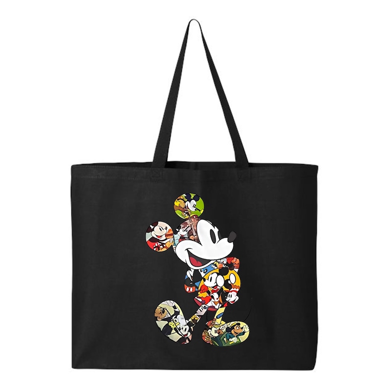 May include: Black tote bag with a colourful Mickey Mouse design. The cartoon character is filled with various images of Mickey Mouse in different poses and outfits. The bag has long black handles.