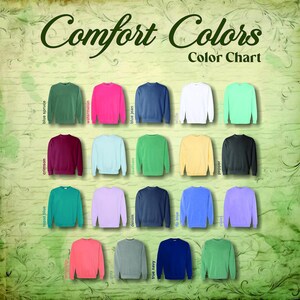 May include: A color chart displaying a variety of Comfort Colors sweatshirts in various hues. The chart includes colors like blue spruce, watermelon, blue jean, and others. The text "Comfort Colors Color Chart" is at the top.